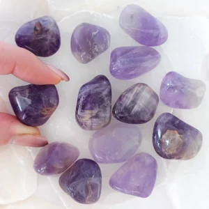 Polished Amethyst tumbled stone with purple tones and slight translucency, natural crystal associated with intuition, clarity, and inspiration.