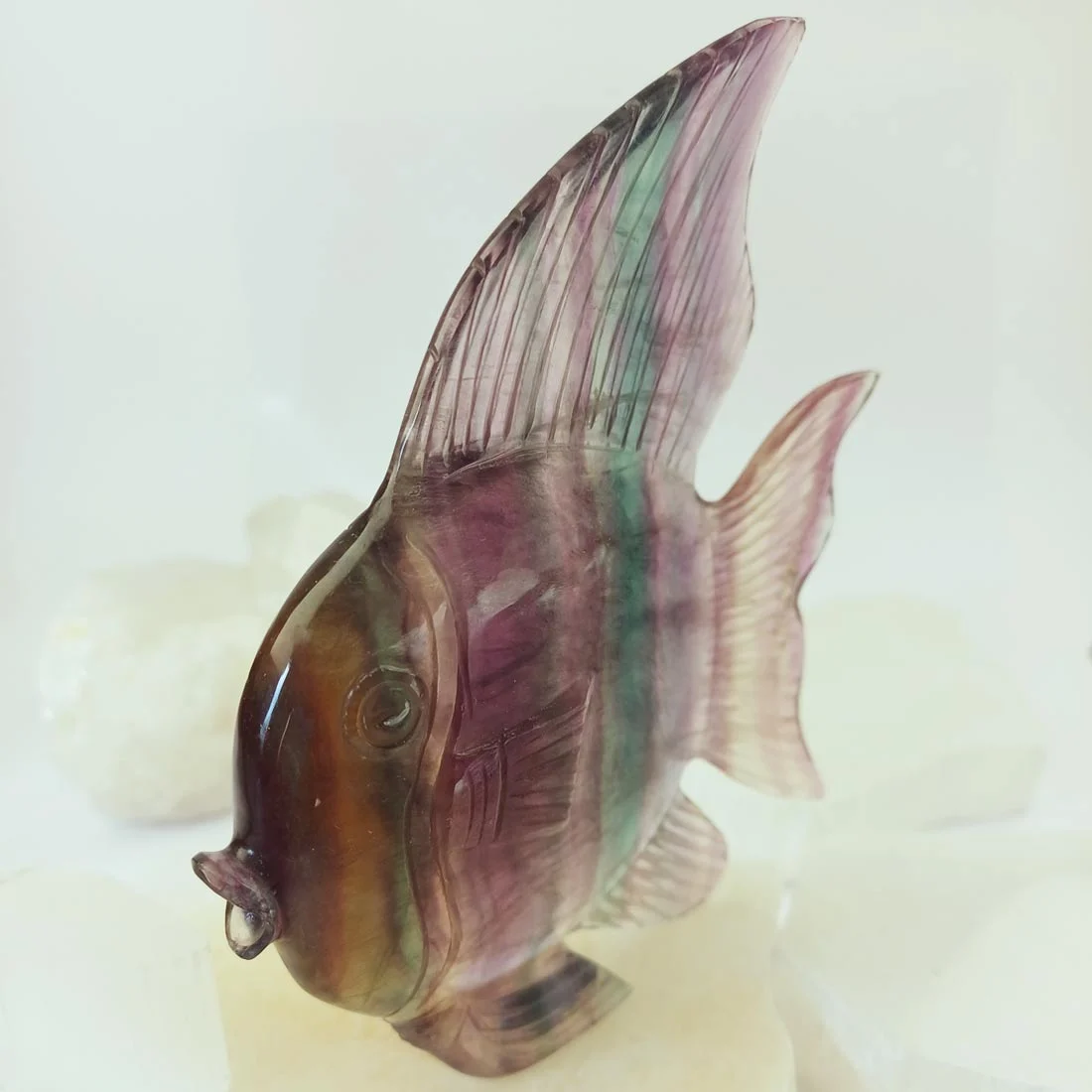 Fish rainbow fluorite carving with visible natural lines.