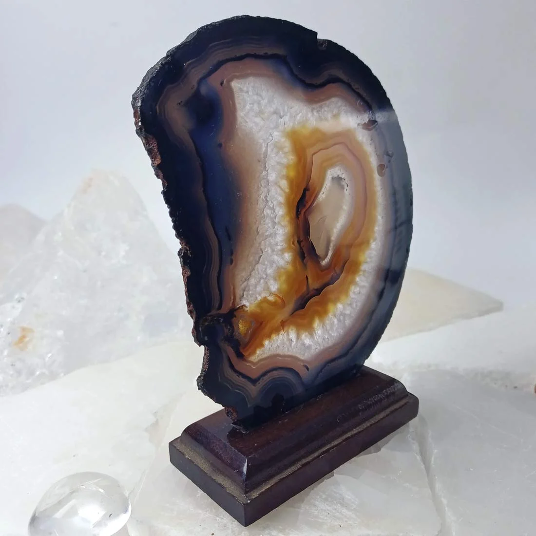 Natural agate slice rock on a removable wooden base.
