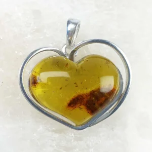 Large heart-shaped amber pendant set in 925 sterling silver, showing warm honey tones and natural internal inclusions.