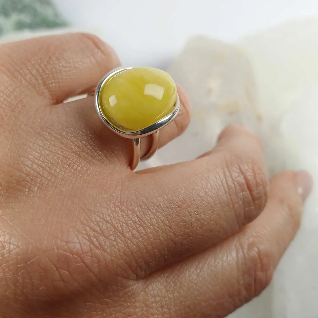 Yellow-toned natural amber ring set in 925 sterling silver, showing warm honey color and smooth polished surface.