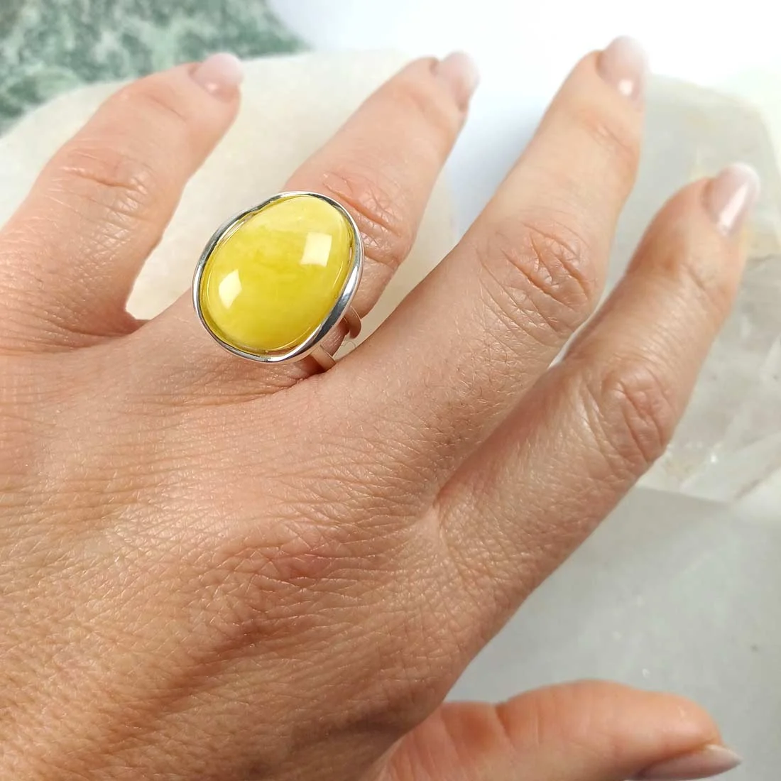 Yellow-toned natural amber ring set in 925 sterling silver, showing warm honey color and smooth polished surface.