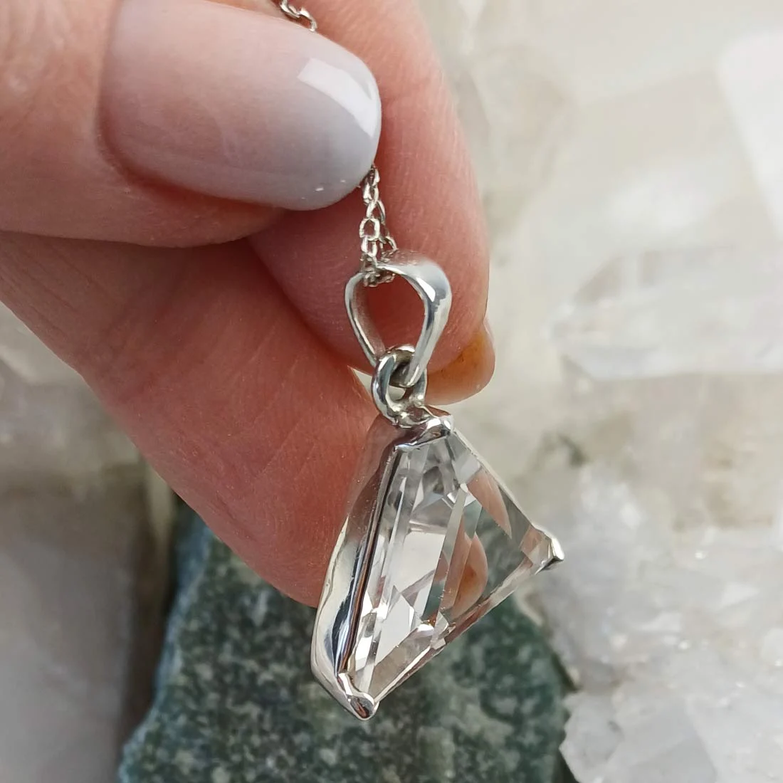 Triangular Clear Quartz pendant set in 925 sterling silver with natural transparency.