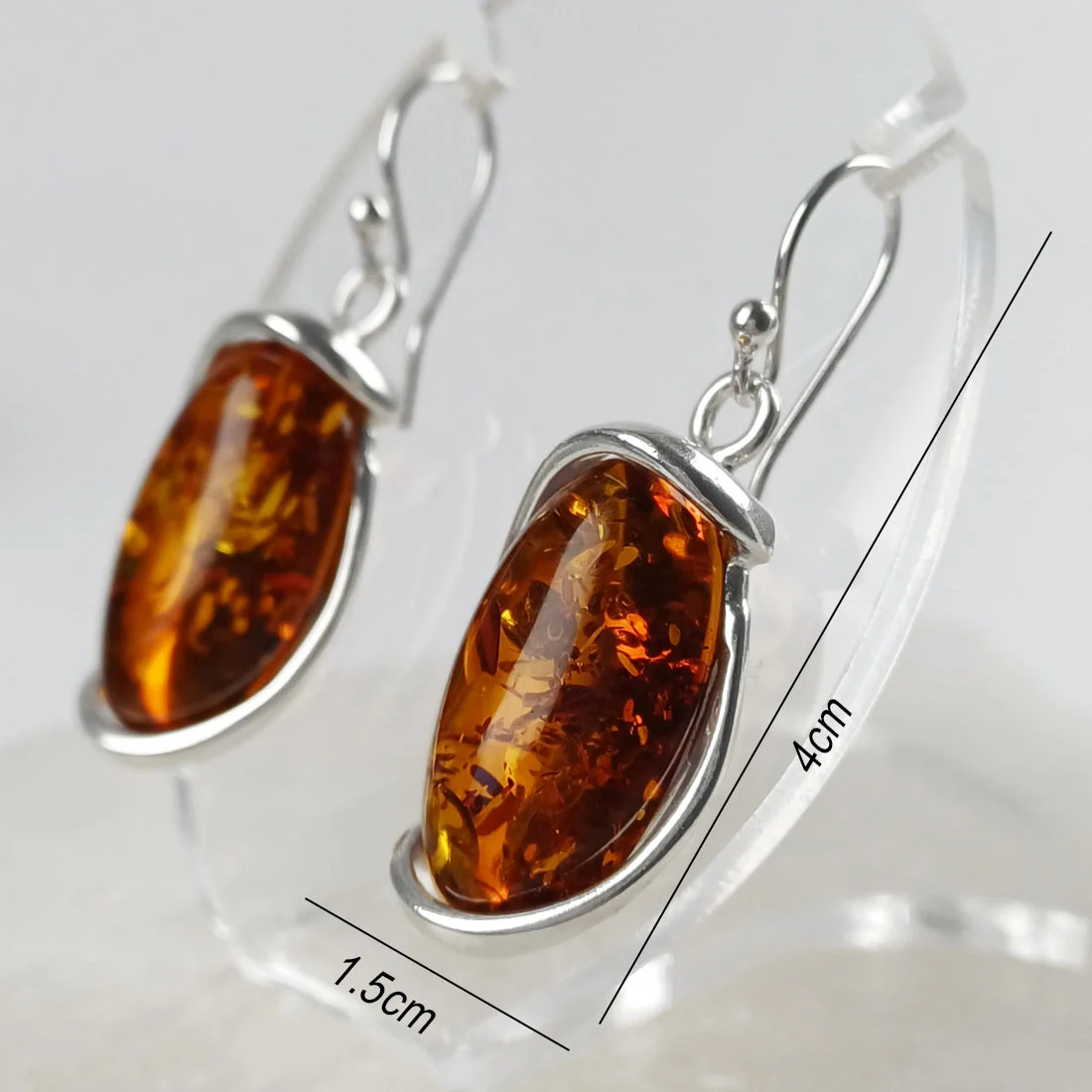 Natural amber large oval earrings set in 925 sterling silver, showing warm golden tones and natural internal inclusions.