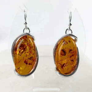 Natural amber large oval earrings set in 925 sterling silver, showing warm golden tones and natural internal inclusions.