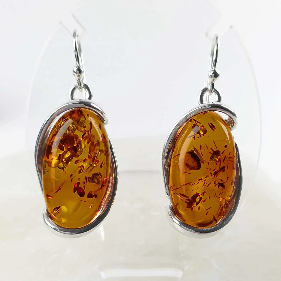 Natural amber large oval earrings set in 925 sterling silver, showing warm golden tones and natural internal inclusions.