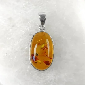 Oval orange-toned amber pendant set in 925 sterling silver, showing warm honey-orange color and natural internal inclusions.