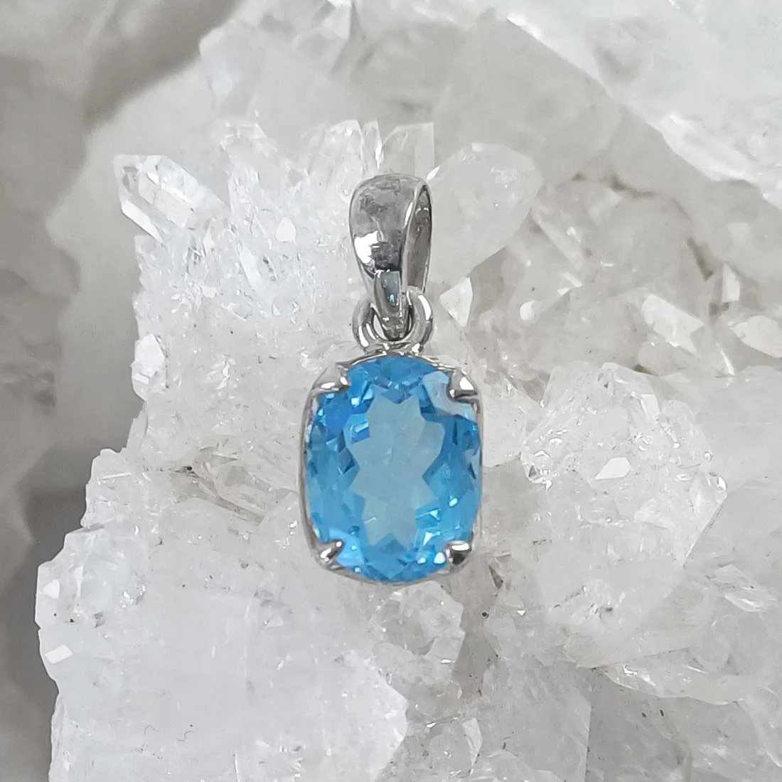 Oval faceted Blue Topaz pendant featuring a natural blue crystal set in 925 sterling silver