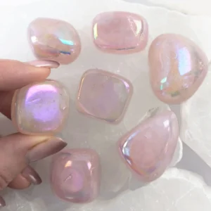 Angel Aura Rose Quartz tumbled stone with soft pink color and iridescent rainbow sheen, polished crystal associated with love and emotional balance.
