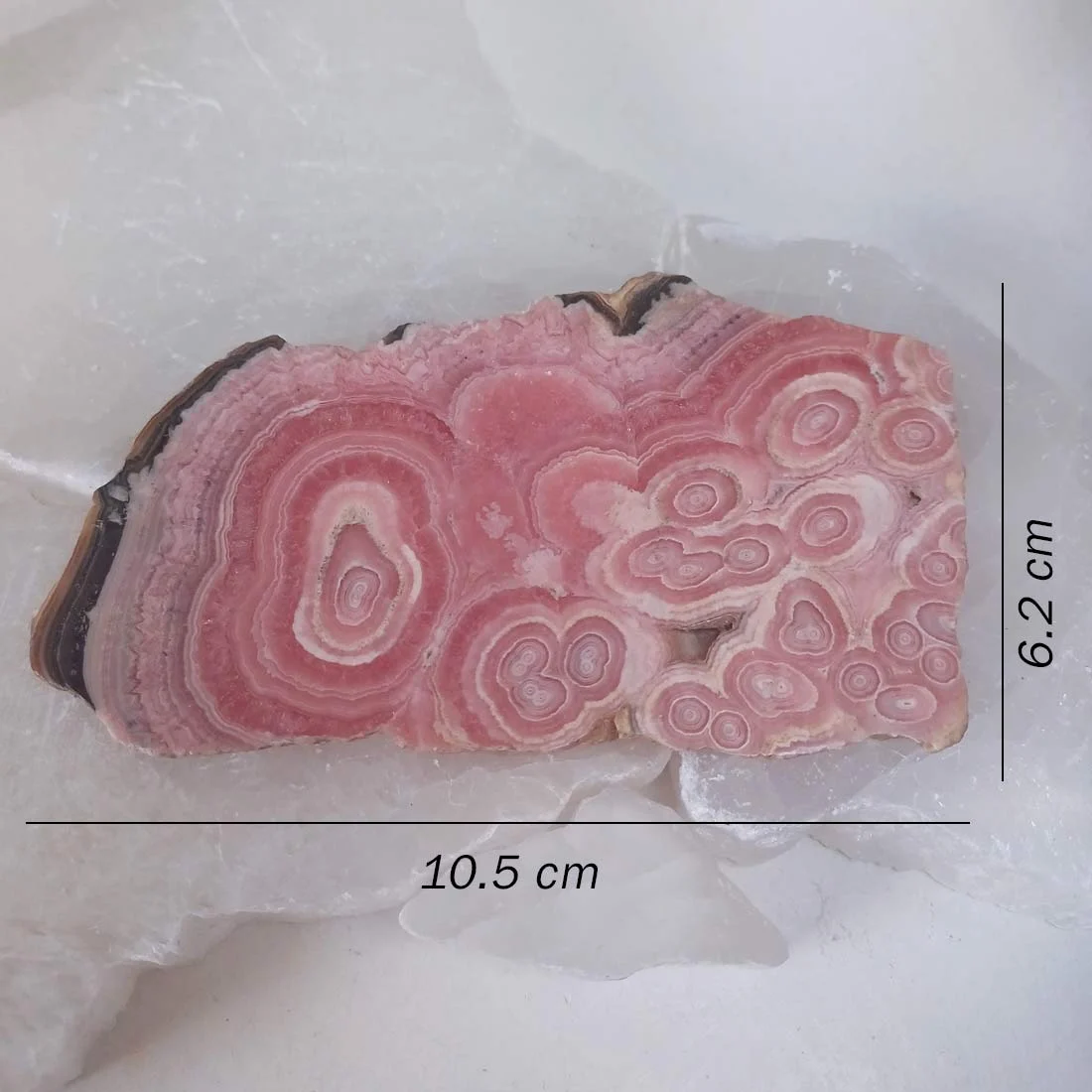 Polished Rhodochrosite palm stone with natural pink, cream, and red banded patterns