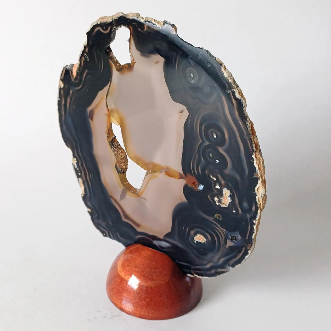 Natural agate slice mineral on a removable wooden base.