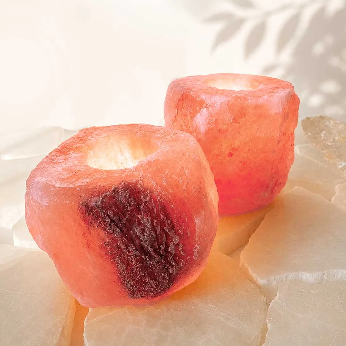Natural Himalayan Salt Candle Holder carved from genuine Himalayan salt crystal with a warm amber glow from a tealight candle.