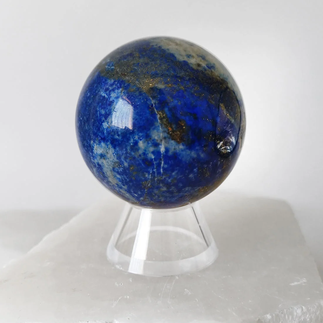 Natural polished Lapis Lazuli sphere with deep blue colour and natural pyrite inclusions.