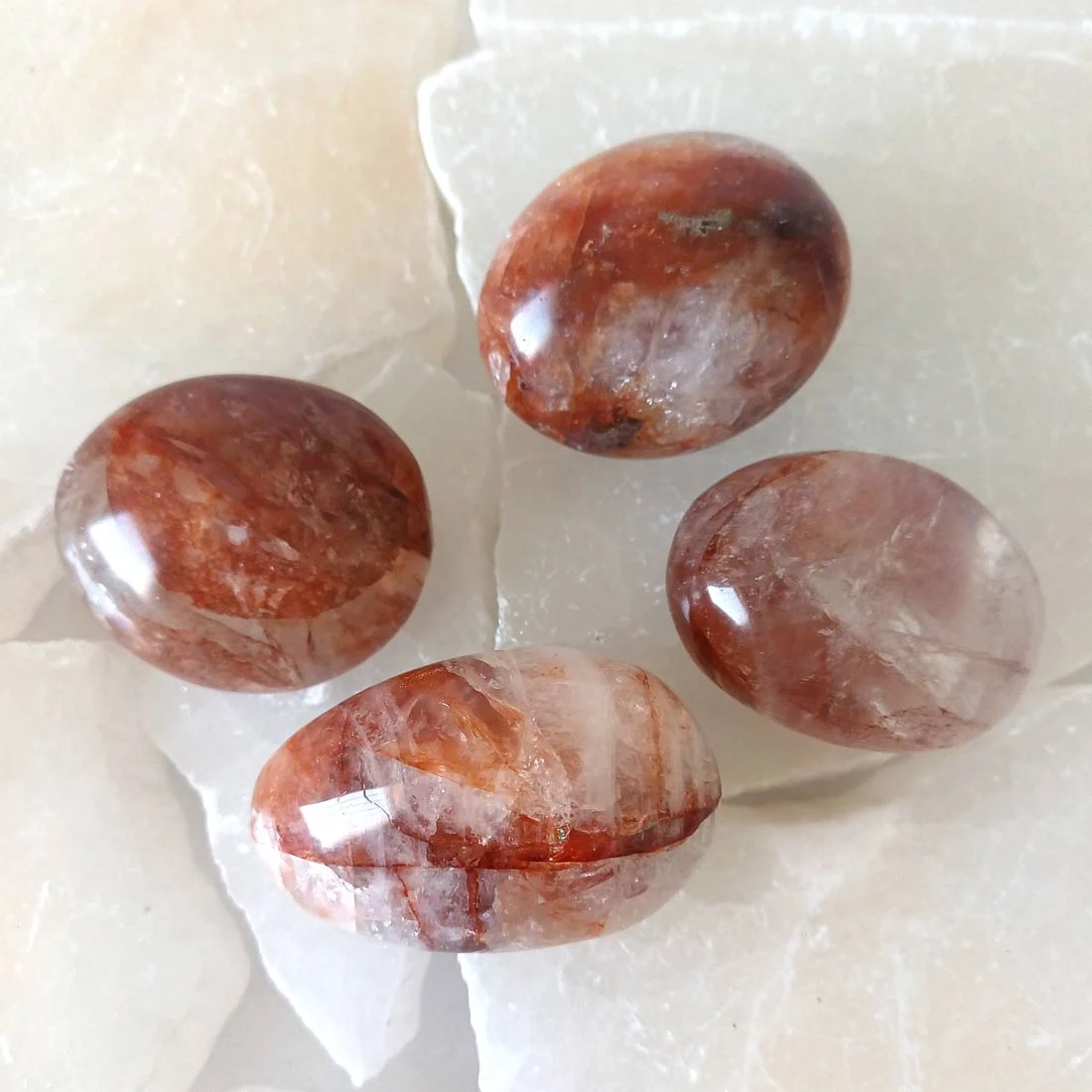 Red Hematoid Quartz palm stone with red and orange iron-rich inclusions and a smooth polished surface